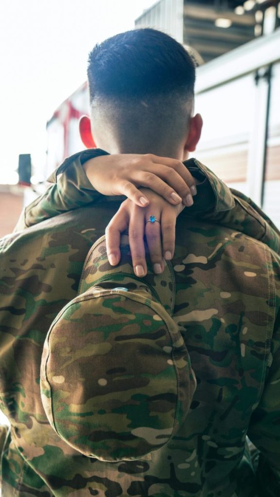 A touching moment of a soldier embraced by a loved one, highlighting reunion and emotion.